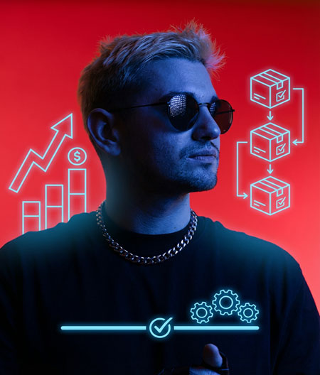 A portrait of a man with light, possibly bleached hair, wearing a heavy silver chain necklace and round sunglasses. The subject is mostly illuminated with a cool blue light against a solid, dramatic red background.